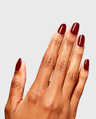 Hand displaying glossy deep beet red nails with OPI Skip a Beet RapiDry polish, a rich fall nail color, on a clean light gray studio background.
