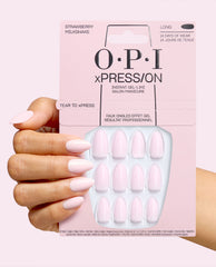 OPI xPRESS/ON Strawberry Milkshake long press-on nails in soft pale pink shown on a manicured hand holding the matching pink instant gel-like salon manicure package.