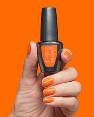 Hand with glossy orange nails holding OPI Peel Good Factor at-home gel nail polish bottle against a bright orange background.