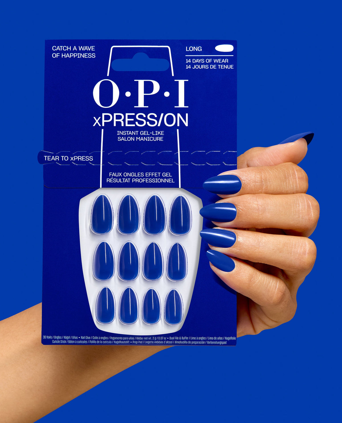 OPI xPRESS/ON Catch a Wave of Happiness long cobalt blue press-on nails shown on a hand beside matching retail packaging against a vivid blue background.