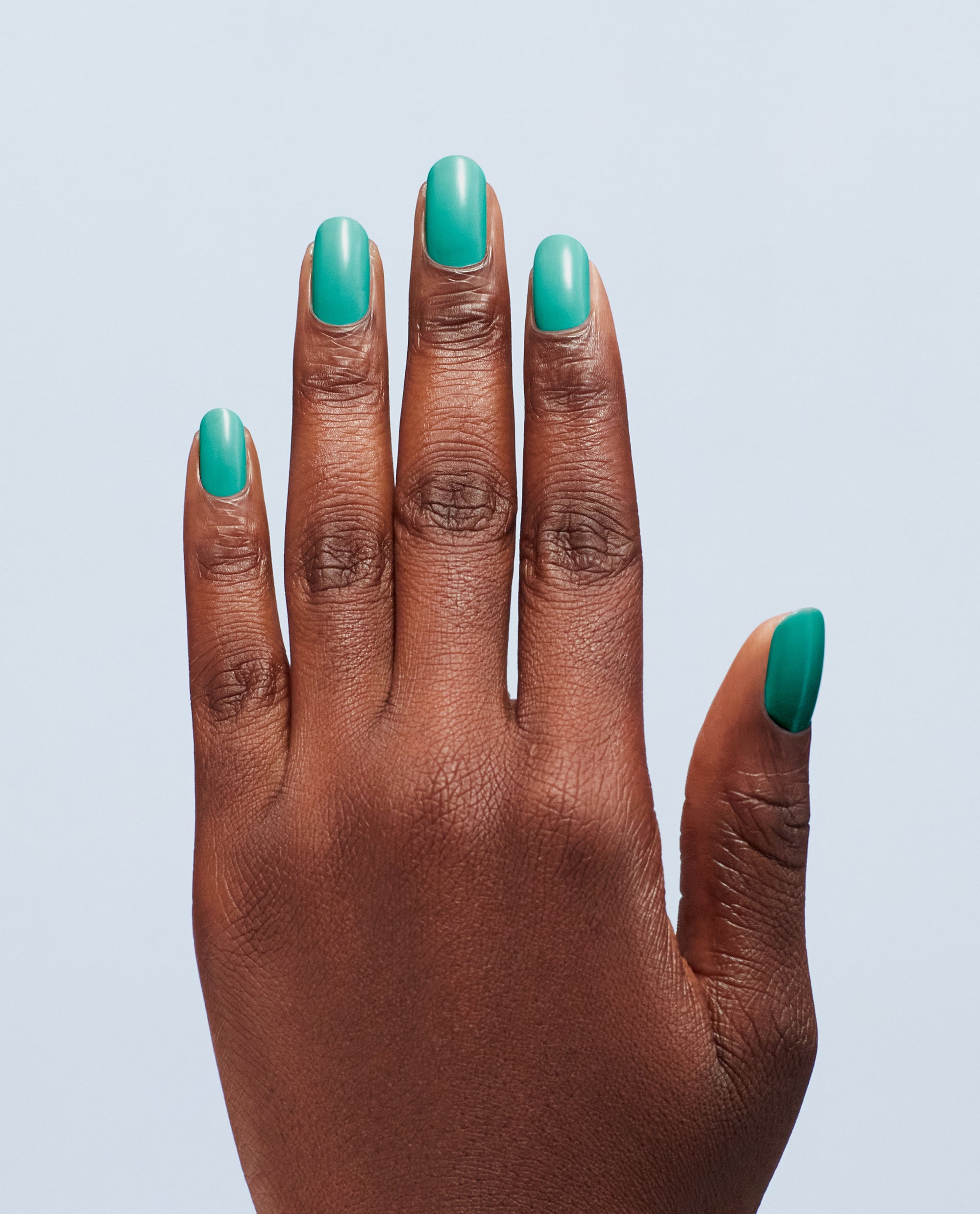 OPI I’m Yacht Leaving nail lacquer coating short, rounded nails, showcasing glossy teal green nail polish on a single hand against a light blue backdrop—fresh, vibrant, and perfect for spring nail colors.