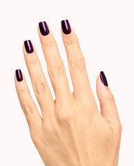 Hand modeling OPI Lincoln Park at Midnight Nail Lacquer, a glossy deep plum-purple manicure with squared nails on a clean white background, ideal for fall nail colors.