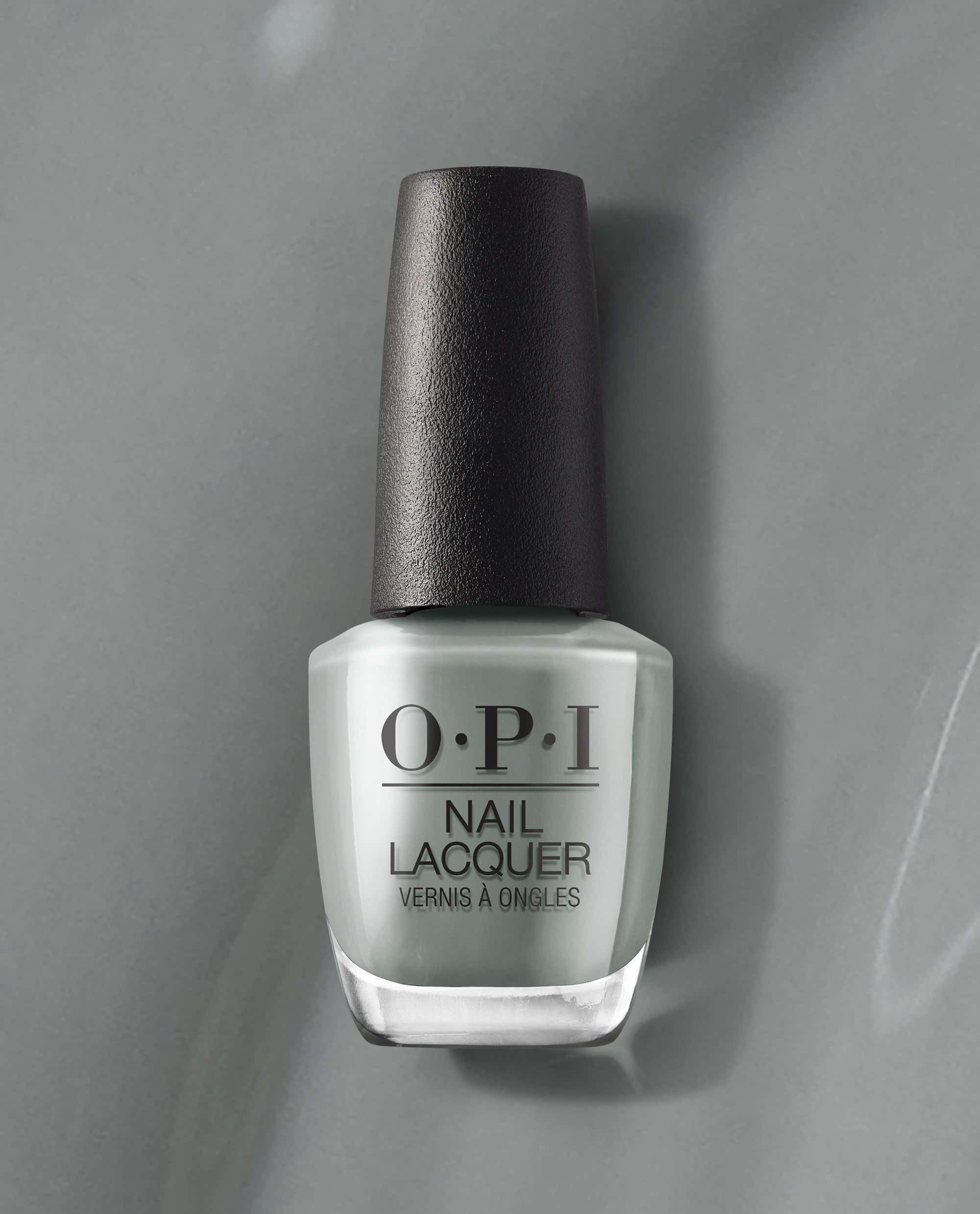 OPI nail polish bottle of Suzi Talks with Her Hands nail lacquer standing upright, showcasing its cool gray shade and black cap against a matching gray background for a modern, minimalist product display.