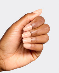Hand displays glossy peach-nude OPI Suzi Take a Vow Gel Nail Polish on squared nails, a soft neutral shade for fall nail colors against a light gray background.